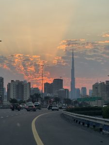 A beautiful scenic sunset view with tall buildings, roads filled with vehicles, and the sky changing its color to orange. Captured in Dubai.