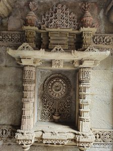A carved niche inside Adalaj Stepwell (Gandhinagar, Gujarat) featuring a floral medallion and miniature spire work in fine sandstone. 