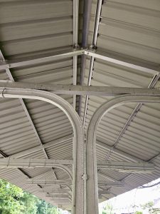 A symmetrical view of the metallic roof support structure at Cochin Harbour Terminus, Kochi. The curved beams and repeating pattern offer an interesting industrial design of the 20th century. 
