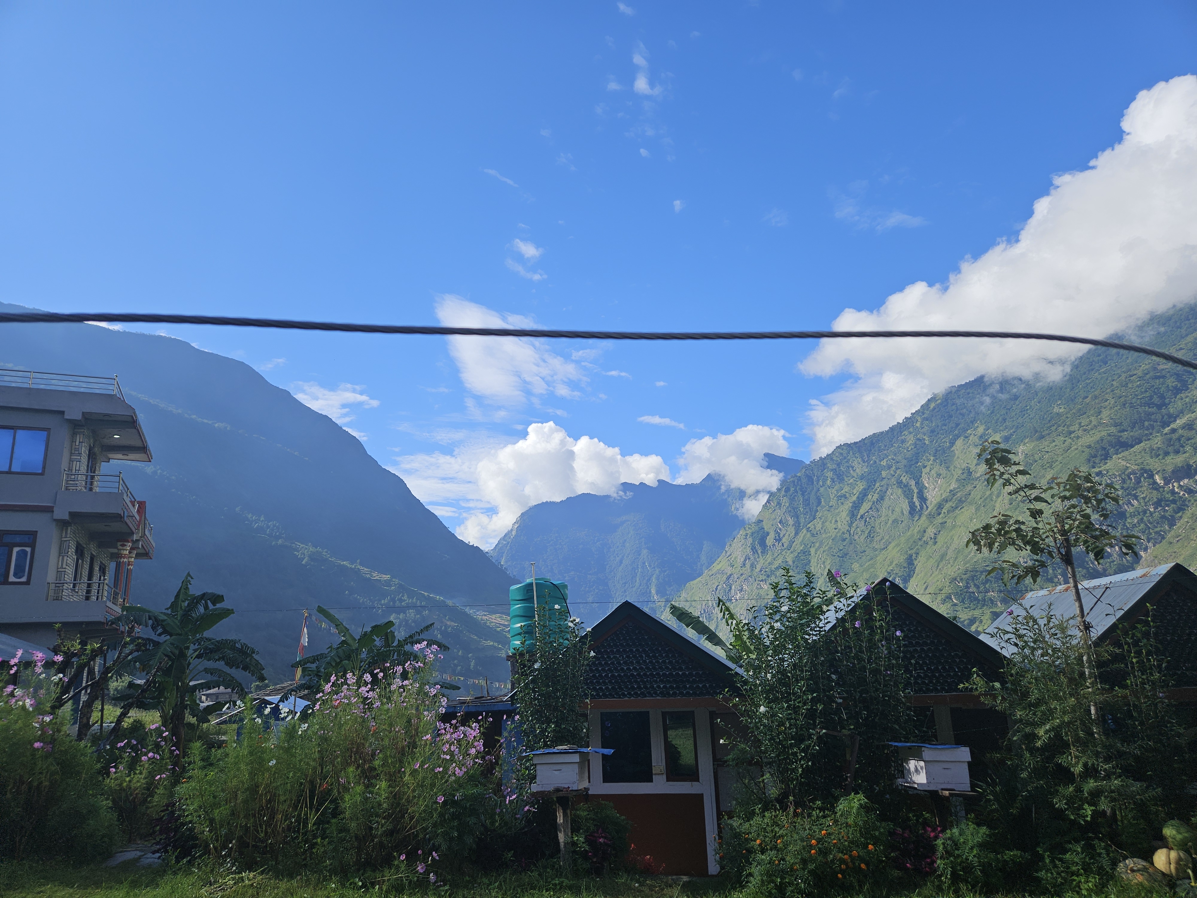 A picturesque mountainous landscape under a bright blue sky with fluffy white clouds.