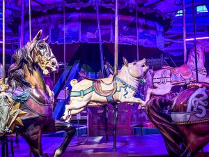 An antique carousel featuring a ride-on wooden pig.
