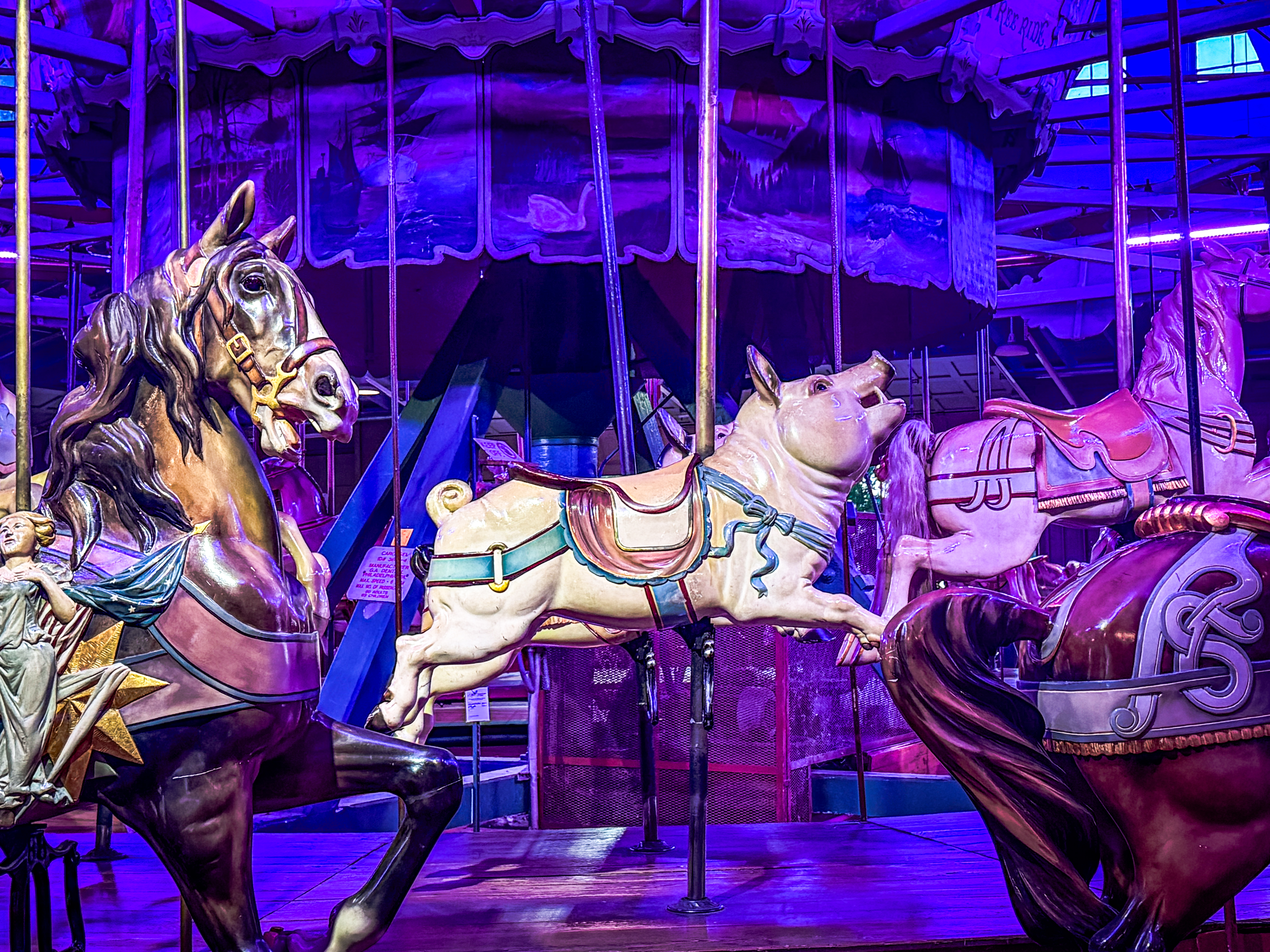 An antique carousel featuring a ride-on wooden pig.