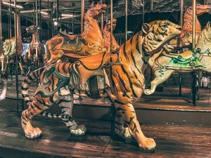 An antique carousel featuring a ride-on wooden tiger.
