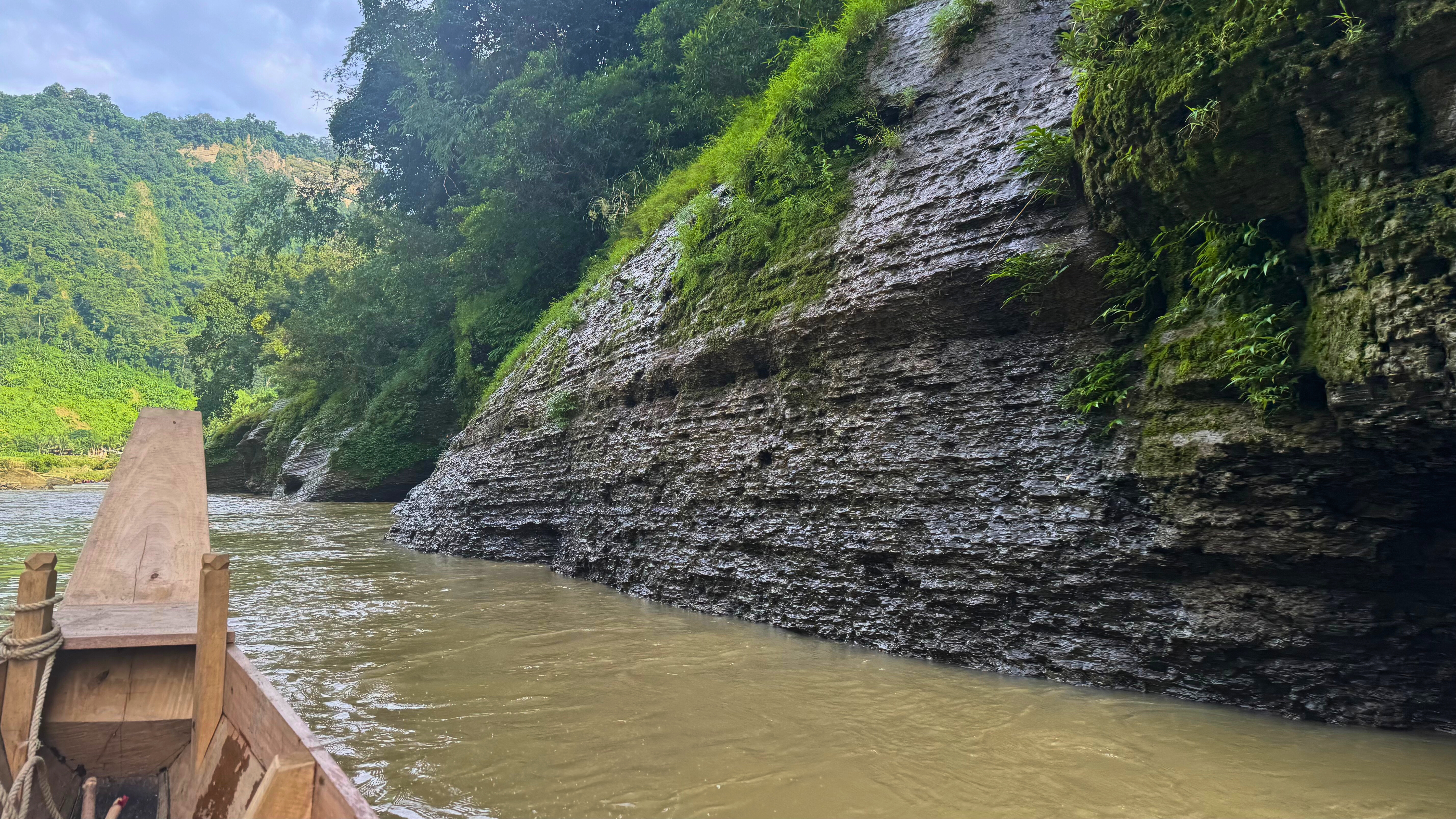 

A wooden boat with a slanted bow points toward the Sangu River in Bandarban, Bangladesh.