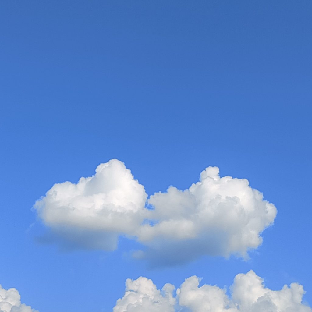 A clear blue sky with scattered white clouds — photo by appealdahal, CC0