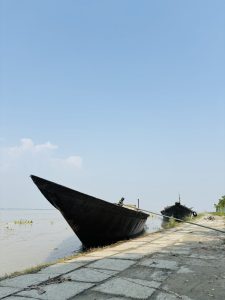 

Two boats tied on a calm river, one close and one farther away.