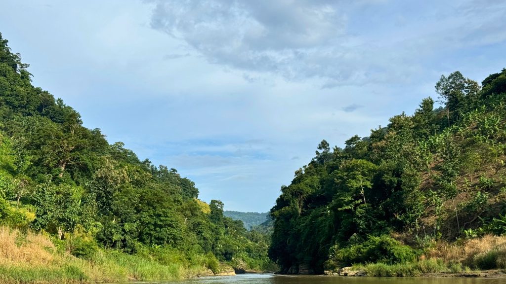 The Sangu River flows amid green hills in Bandarban, Bangladesh.