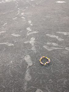 An artificial flower on the sand.