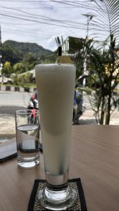 



A frosty drink with a lemon slice sits beside a glass of water.