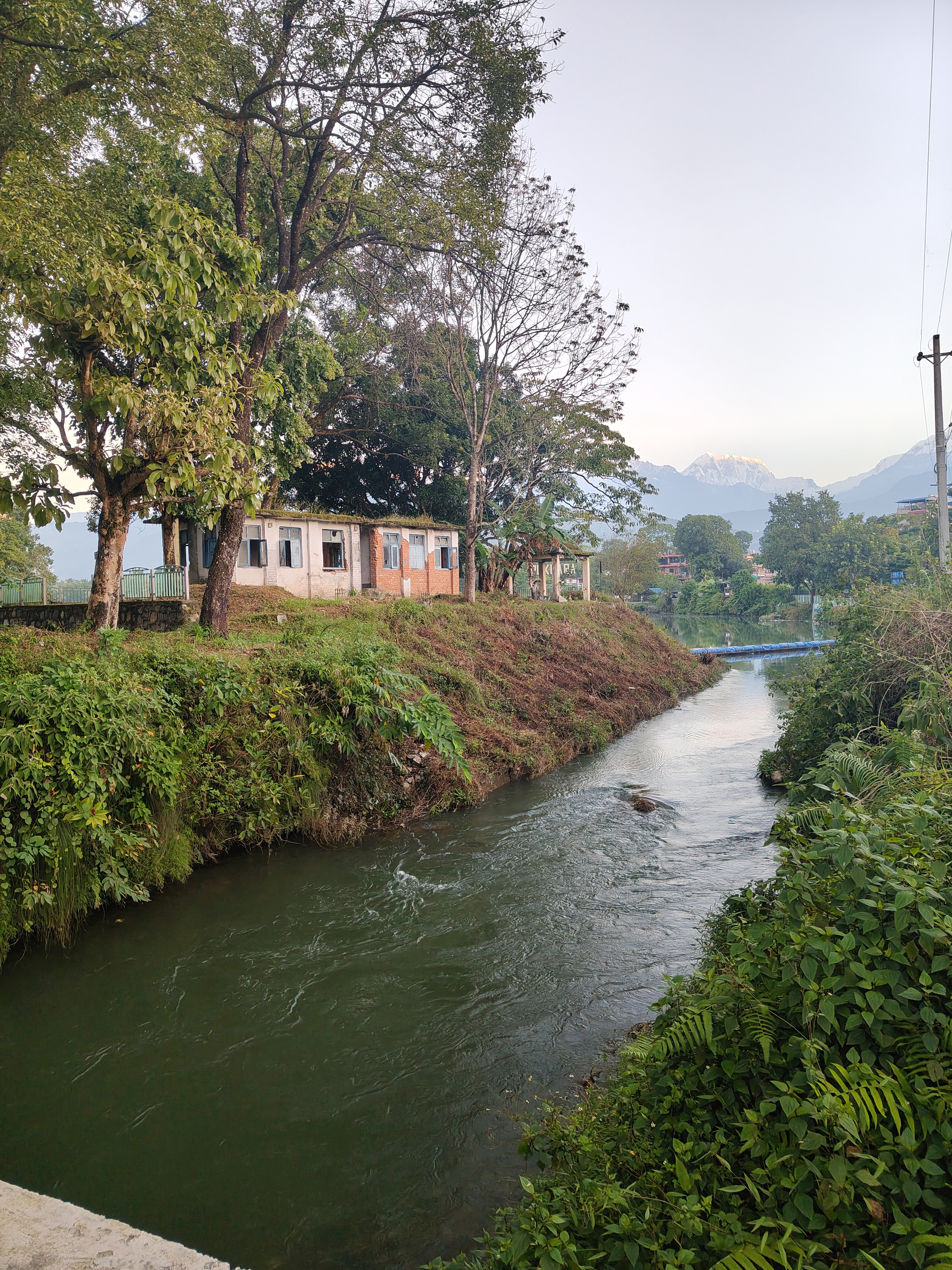 A serene landscape featuring a gently flowing river bordered by lush greenery.