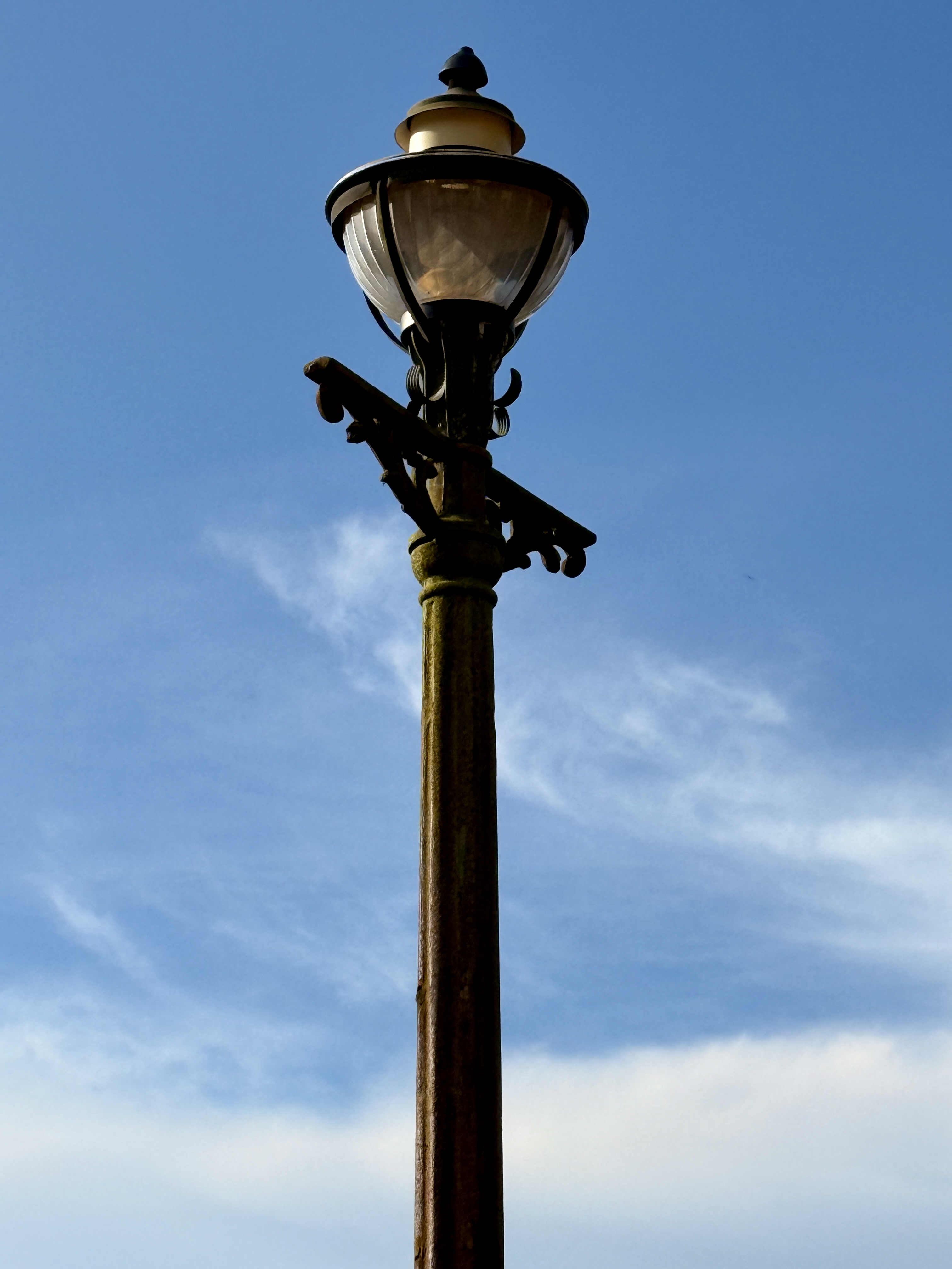 A close-up of an old-fashioned street lamp with a clear blue sky in the background. Captured at Hill Palace, Thrippunithura, Kerala. 