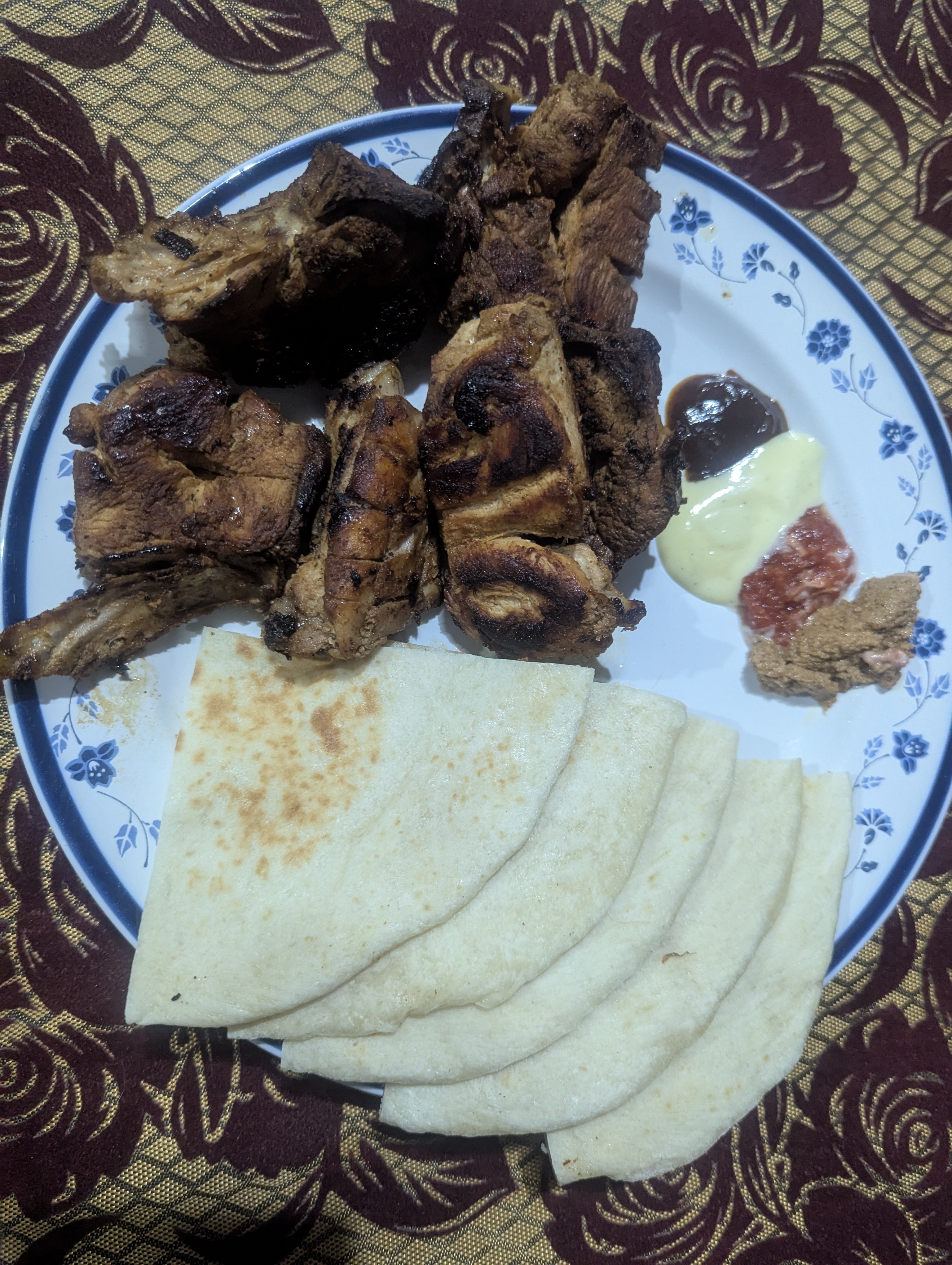 

Char-grilled meat served with folded flatbread and spicy brown chutney.