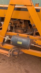 Engine assembly of a tractor with an air tank with a writeen note, please remove water daily