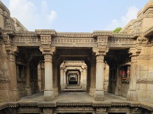 The Adalaj Stepwell in Gandhinagar, Gujarat, is a five-story-deep, intricately carved structure that showcases the beauty of Indian architecture. Rows of stone columns with floral patterns and detailed brackets support its stepped levels.