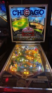An older style pinball machine with visible different colours, lights, and letters. The theme of the game is the Chicago Cubs.