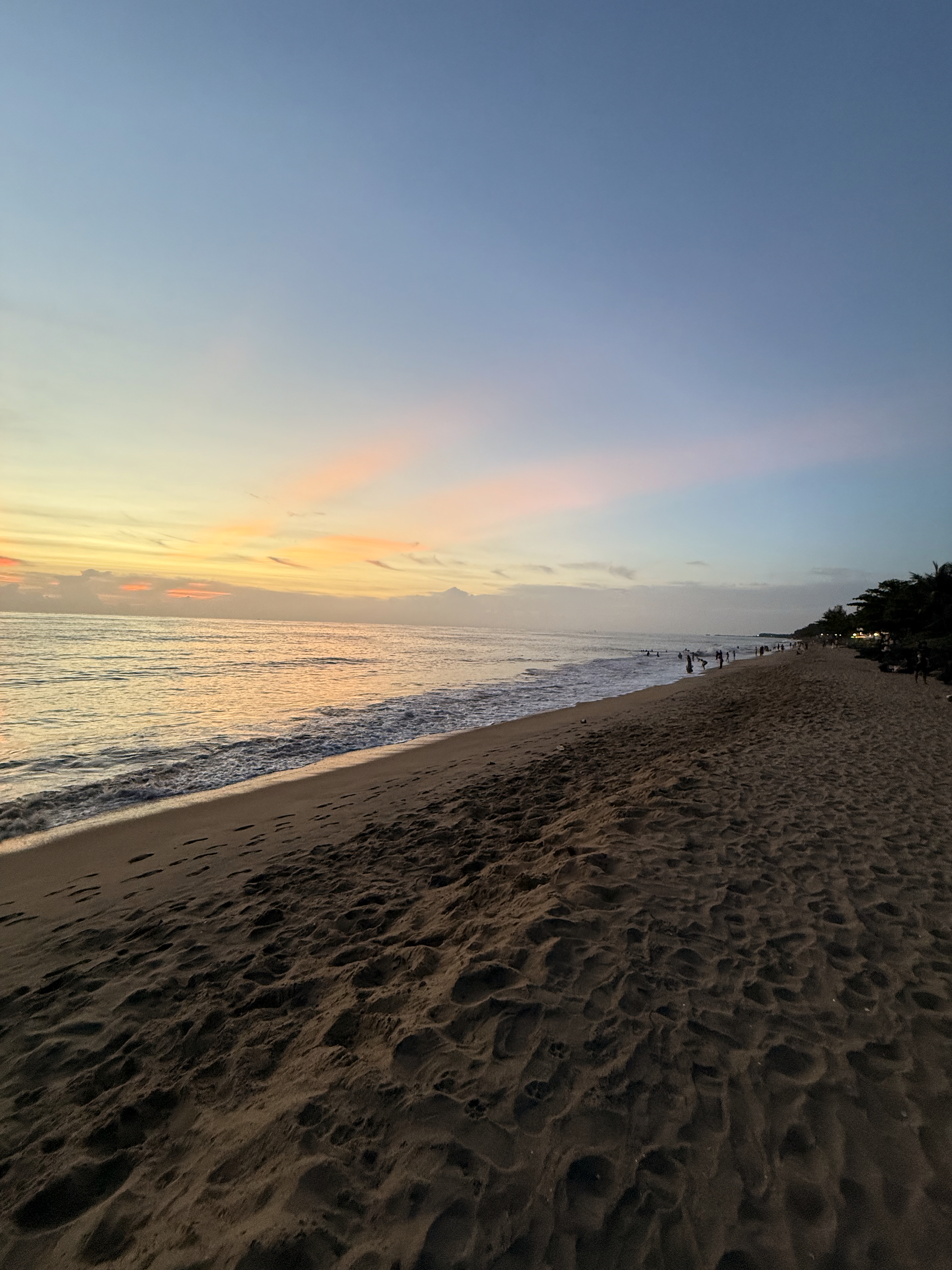 A calm evening at Cherai Beach, Ernakulam, with smooth waves and a pastel orange-blue sunset sky.