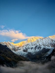 Early morning view of Mount Annapurna, glowing golden, as seen from Annapurna Base Camp, Nepal.