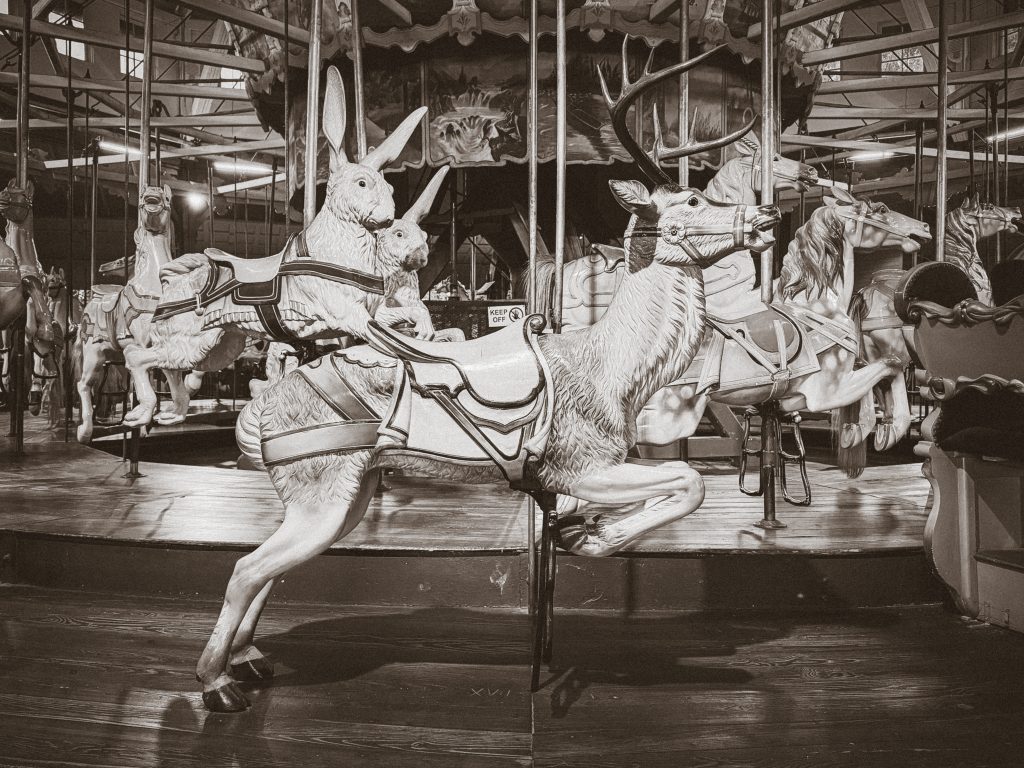 An antique carousel featuring a ride-on wooden reindeer.