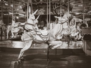 An antique carousel featuring a ride-on wooden reindeer.
