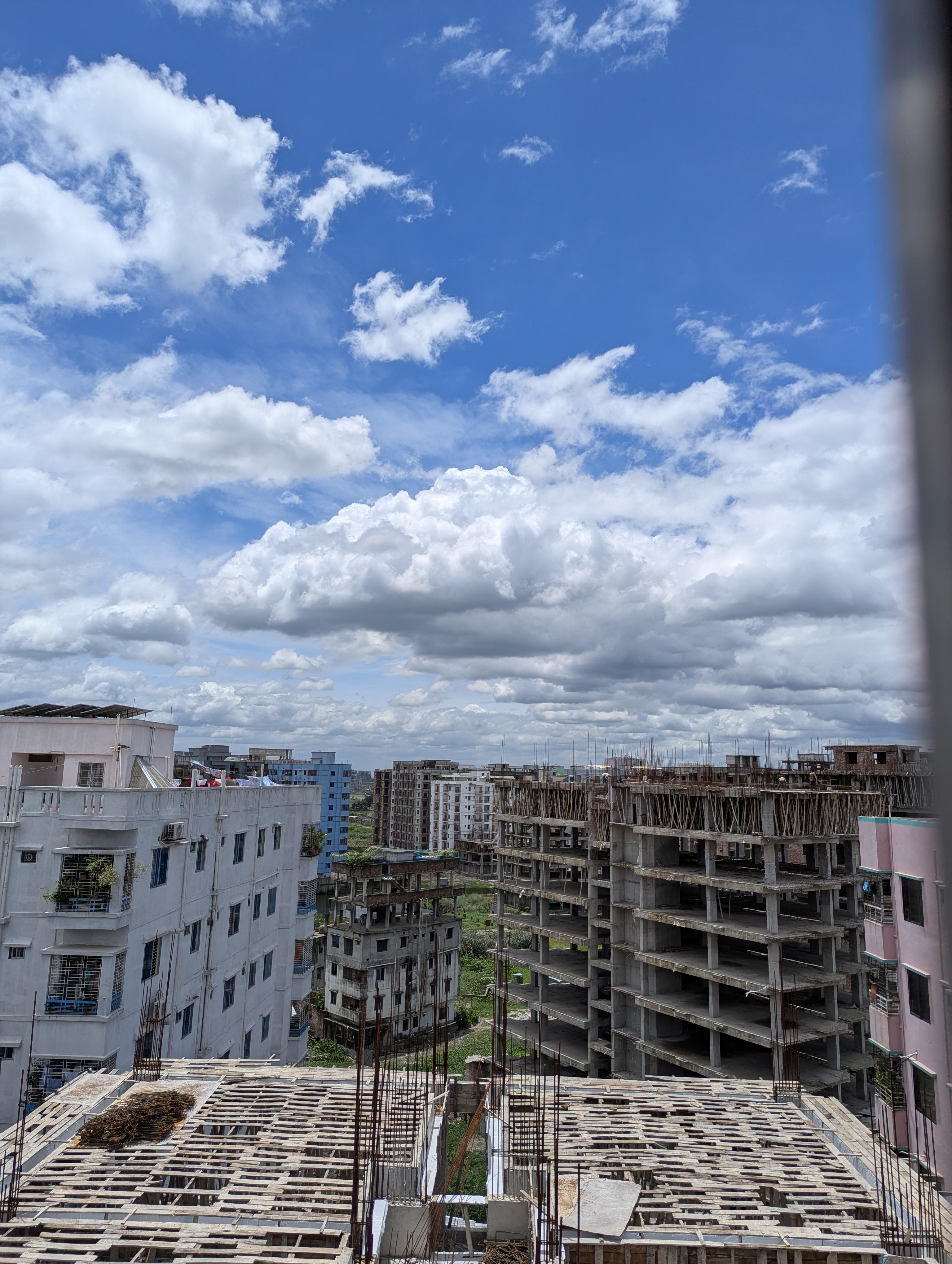 A beautiful picture of a clear, Cloudy Sky with tall apartment buildings.