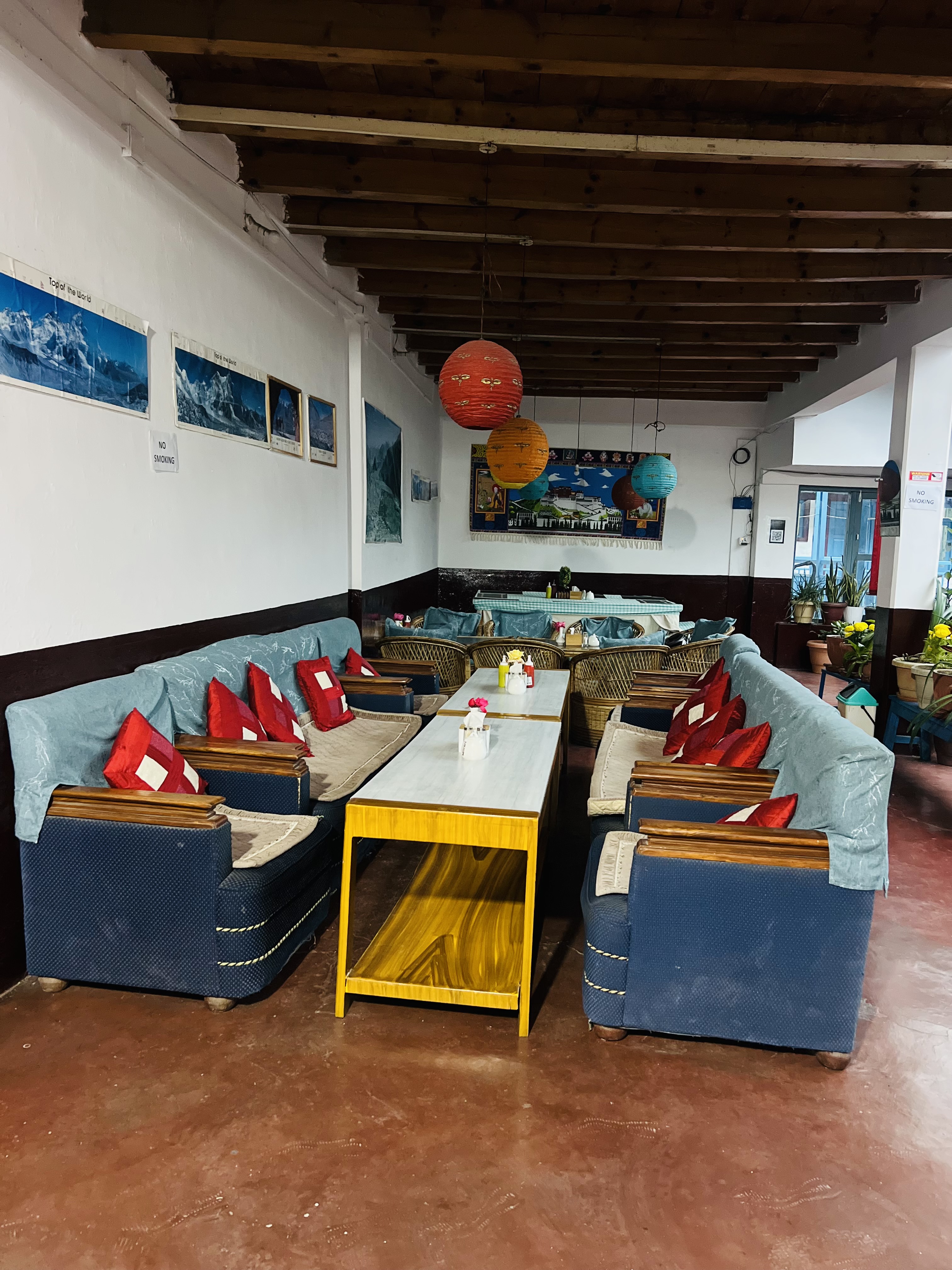 
A cozy indoor seating area with blue sofas and red cushions.
