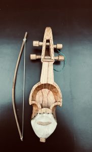 A Sarangi. The sārangī is a bowed, short-necked three-stringed instrument played in traditional music from South Asia.  Made of wood.