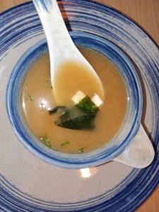 Miso soup with nori seaweed and tofu served on a white and blue coloured bowl and plate at Izakaya Restaurant, Dhaka, Bangladesh