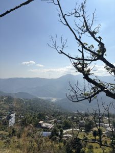 A panoramic view of a mountainous landscape featuring rolling hills covered in greenery.