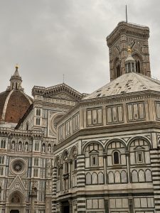 A view of Florence’s Cathedral, Baptistery, and Giotto’s Bell Tower under a cloudy sky.