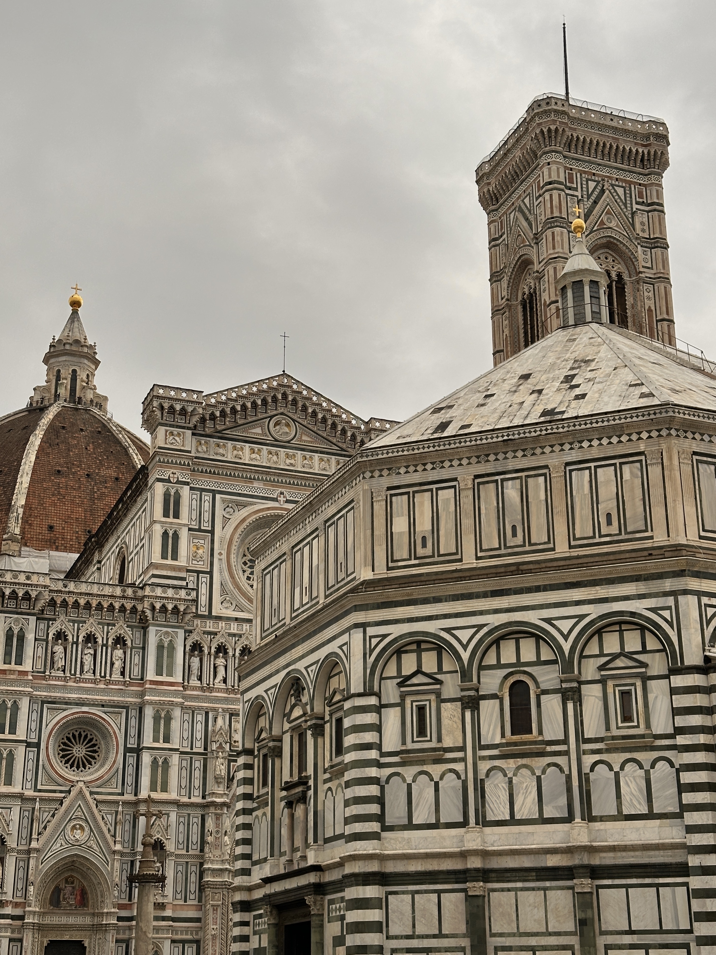 A view of Florence&rsquo;s Cathedral, Baptistery, and Giotto&rsquo;s Bell Tower under a cloudy sky.