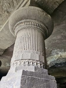 Close-up of a beautifully carved fluted stone pillar with fine vertical ridges and decorative patterns. Captured at Elephanta Caves, Mumbai, Maharashtra. 