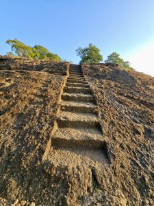 Ancient steps carved into the rock lead up the hill at Kanheri Caves, glowing in the warm evening sunlight. Taken from Kanheri Caves in Borivali, Mumbai. 