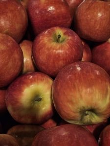 A group of dark red apples is placed together. The bright red tones and round shapes show the freshness of the fruits. Captured from a market in Kozhikode, Kerala. 