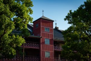 A historical red brick warehouse captured at sunset with a deep blue sky. The building’s silhouette and sharp architectural lines highlight a vintage industrial charm.
