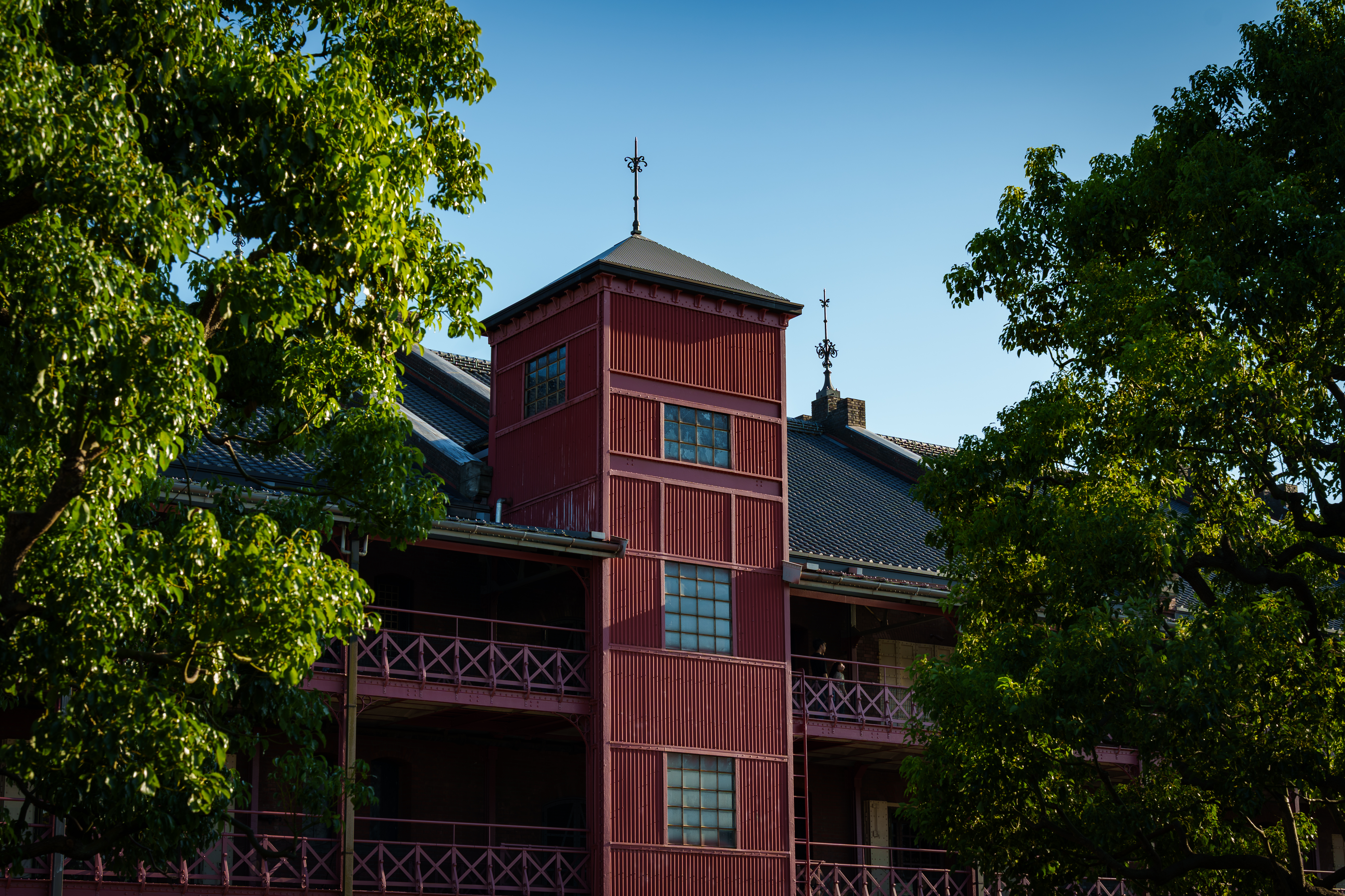 A historical red brick warehouse captured at sunset with a deep blue sky. The building’s silhouette and sharp architectural lines highlight a vintage industrial charm.