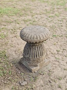 A small carved stone seat with intricate patterns sits on the ground near the Elephanta Caves in Mumbai, showcasing the craftsmanship of earlier times. 