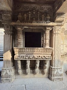 Ornately carved stone balcony window at Adalaj Stepwell in Gandhinagar, Gujarat. The intricate latticework and sculpted pillars showcase the brilliance of Indo-Islamic architecture, photo taken in natural light. 
