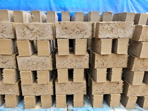 Neatly arranged interlocking mud bricks are seen in a production unit. These eco-friendly blocks are used in sustainable building, captured in Perumanna, Kozhikode, Kerala.