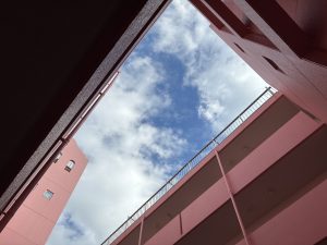 Gazing at the blue sky from the atrium of the pink apartment building