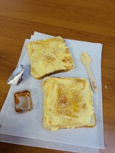Two slices of toasted bread with butter, placed on a paper napkin.
