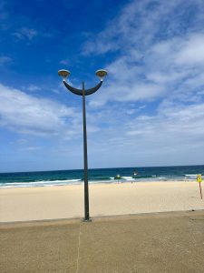 A smiley face depicting lamp post by the sea on a clear blue sky!