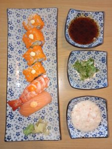 Maki rolls and sushi served with soy sauce, ginger, and wasabi paste at a restaurant in Dhaka, Bangladesh.
