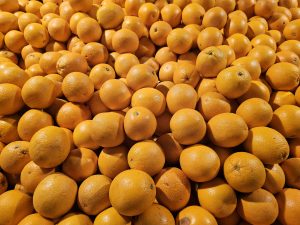 A big pile of fresh, bright Valencia oranges stacked together at a market in Kozhikode, Kerala. The rich orange colour and smooth texture make the fruits look vibrant and ready to enjoy.