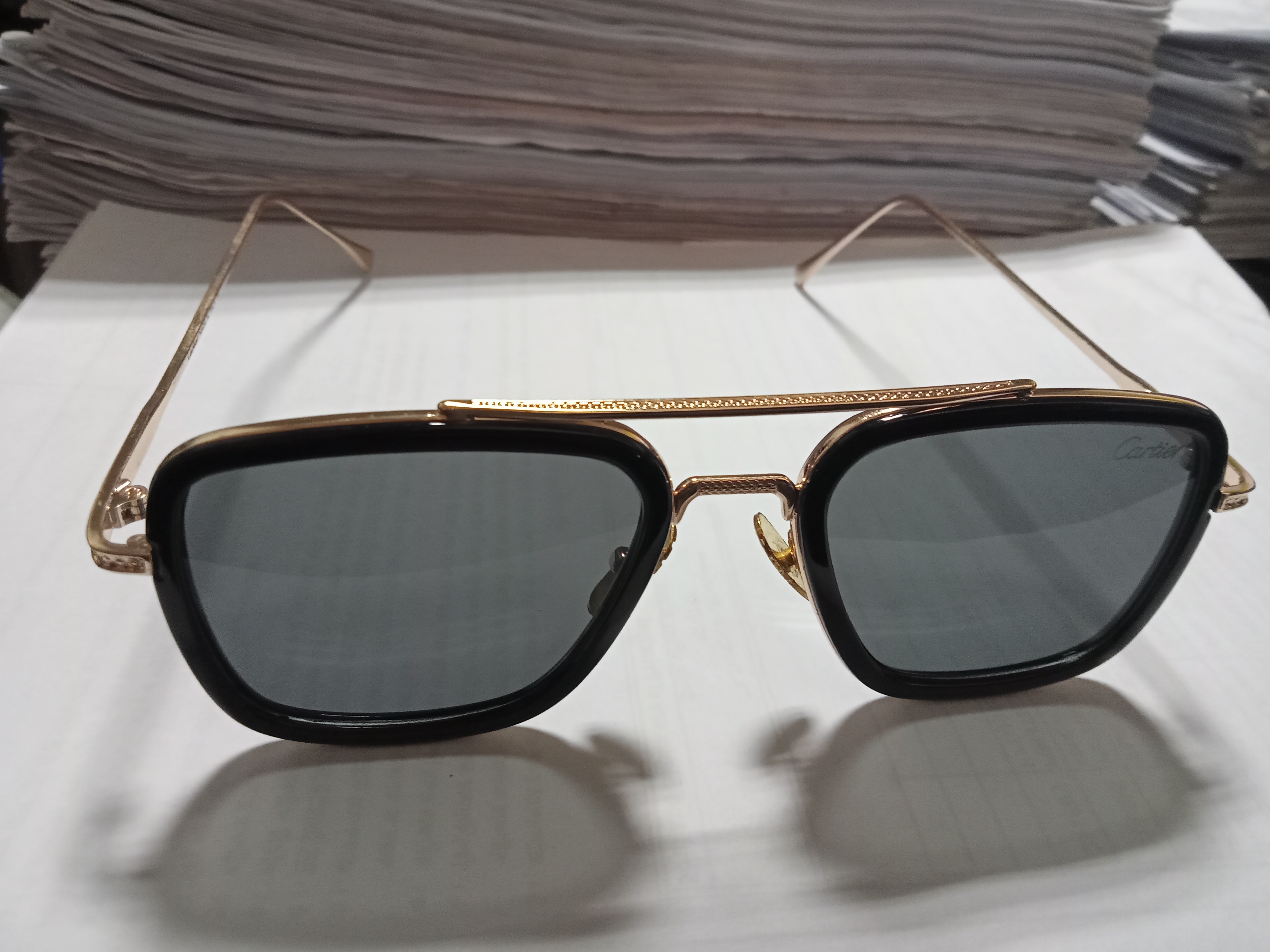 A pair of stylish sunglasses with dark lenses and a sleek gold frame