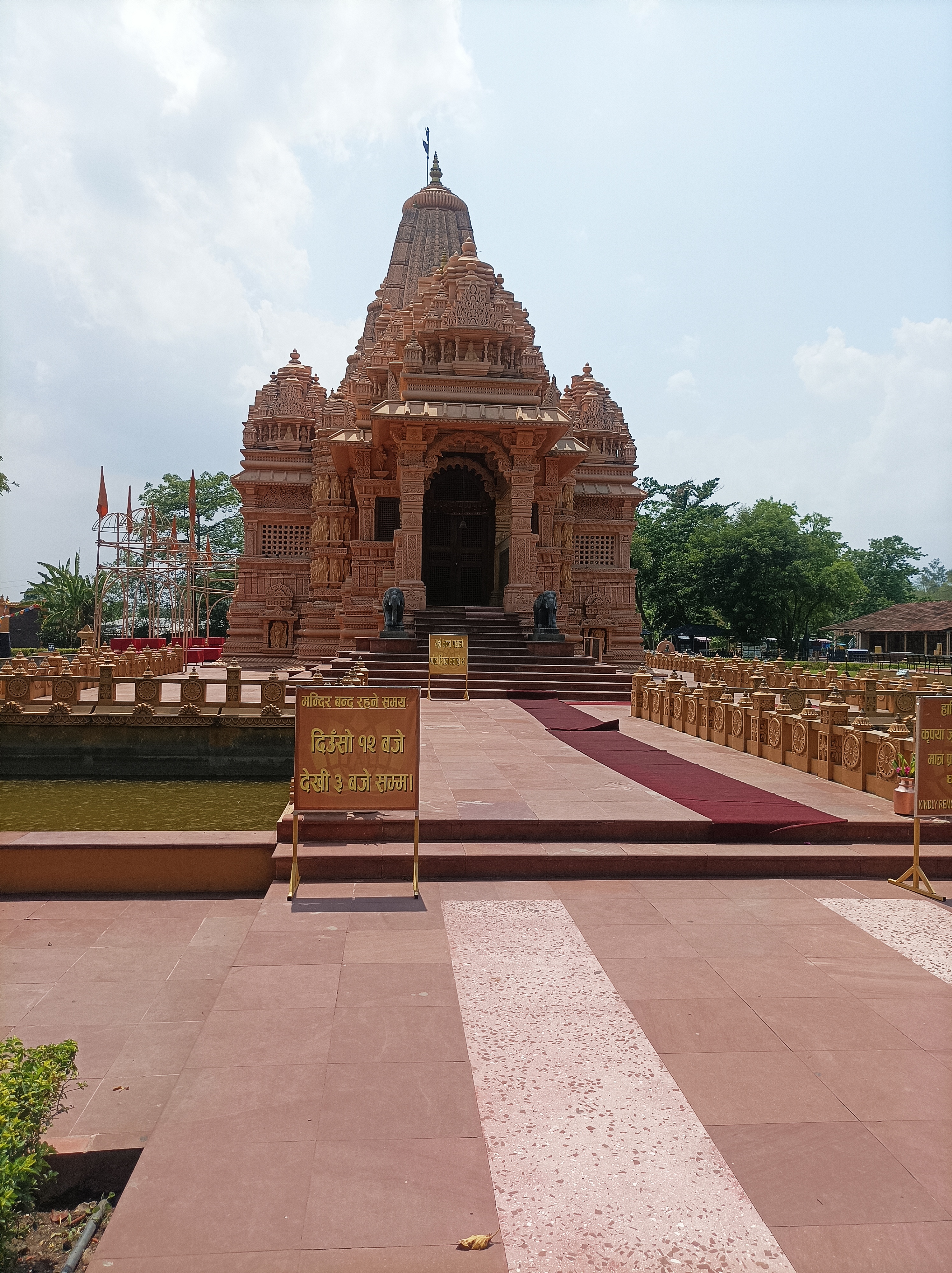A beautifully carved temple with intricate details stands prominently, adorned with multiple domes and spires.