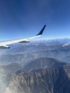 A flight wing in the sky with mountains in the background 