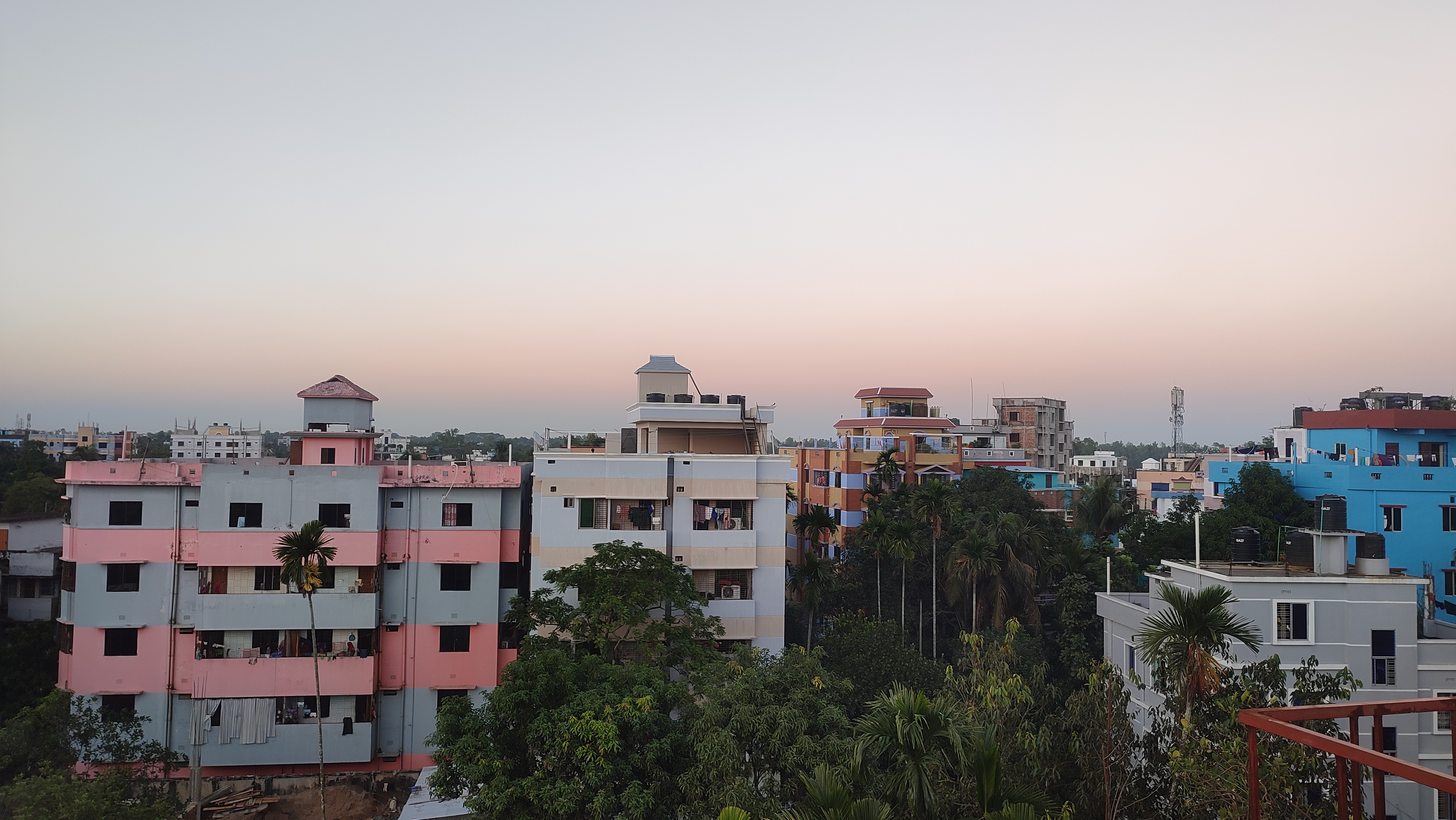 A skyline view of a residential area featuring a variety of buildings with different colors, including pink, blue, and gray.