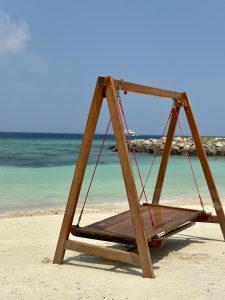 A wooden swing standing tall on a sandy White Sea shore somewhere in Maldives!