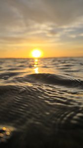 Rippling water reflects the warm colors of a sunset in this close-up scene from Masachapa Beach, Nicaragua.