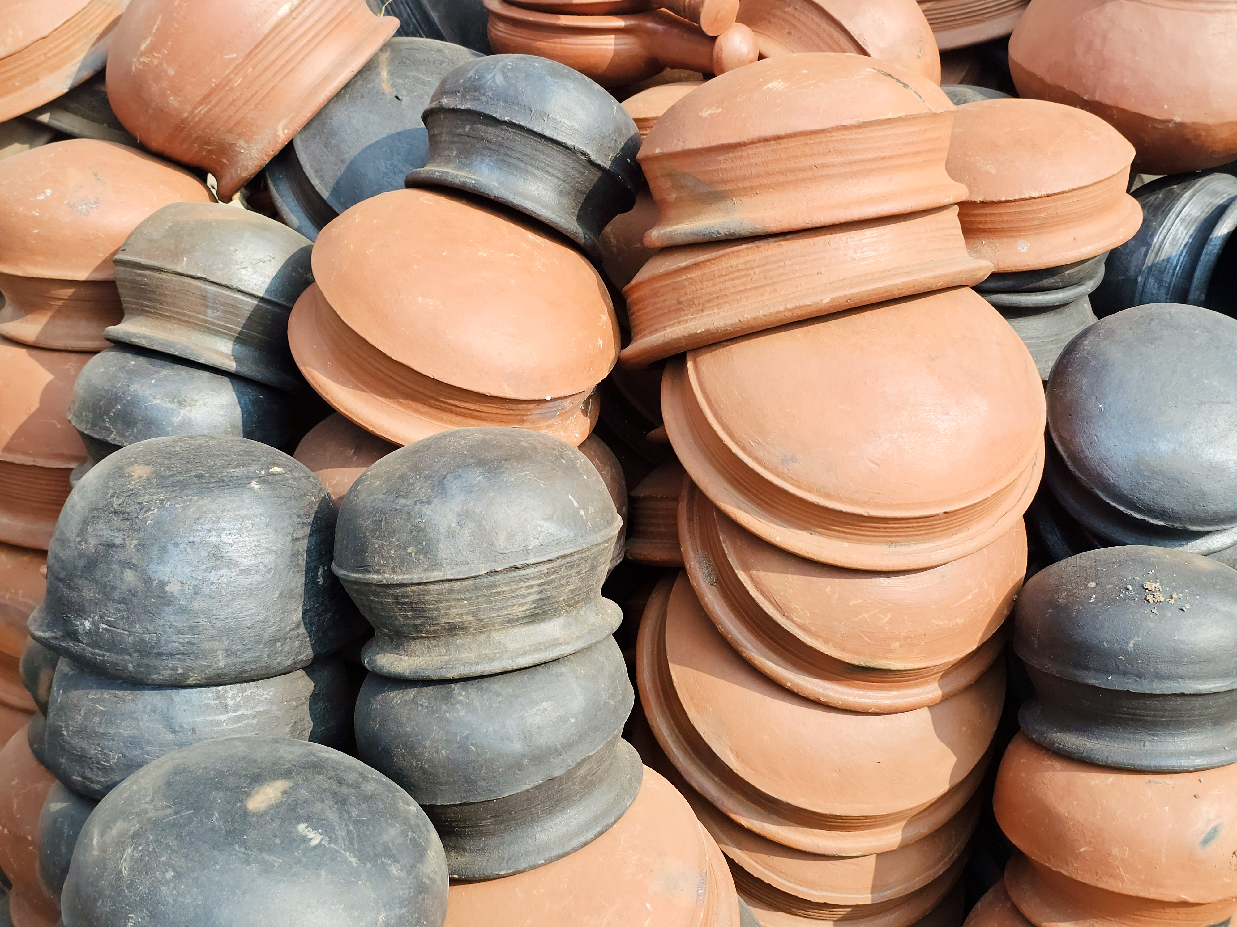 Stacks of traditional terracotta and blackened clay pots in Kozhikode, Kerala. The earthy textures and colours reflect the region’s rich pottery craftsmanship and everyday heritage. 